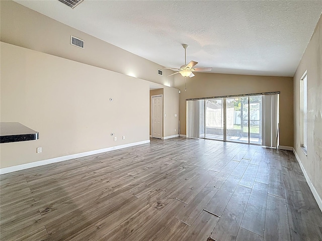 1741 Oak Spring Dr, Tarpon Springs, FL 34689 - spare room with lofted ceiling, a ceiling fan, wood finished floors, and a textured ceiling