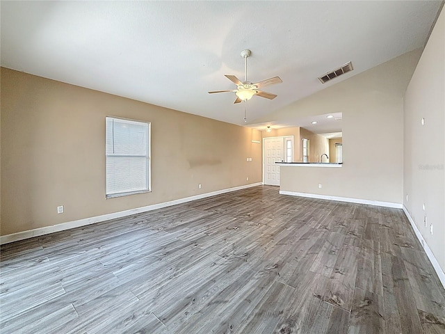1741 Oak Spring Dr, Tarpon Springs, FL 34689 - unfurnished living room with ceiling fan, wood finished floors, and vaulted ceiling
