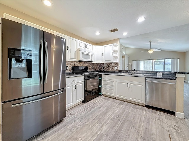 1741 Oak Spring Dr, Tarpon Springs, FL 34689 - kitchen with stainless steel appliances, a peninsula, white cabinetry, ceiling fan, and vaulted ceiling