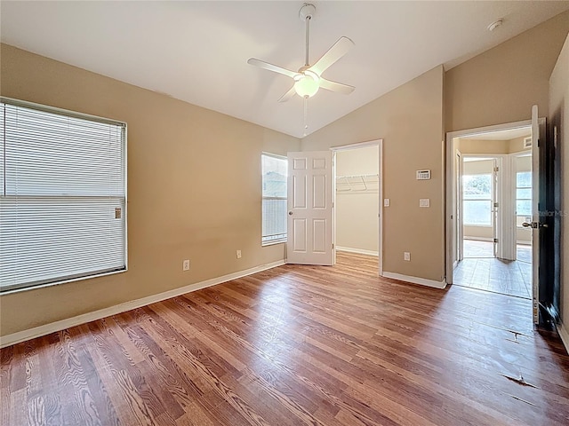1741 Oak Spring Dr, Tarpon Springs, FL 34689 - unfurnished bedroom with lofted ceiling, wood finished floors, a walk in closet, and a ceiling fan
