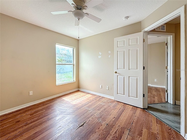 1741 Oak Spring Dr, Tarpon Springs, FL 34689 - unfurnished bedroom with wood finished floors, a textured ceiling, and a ceiling fan