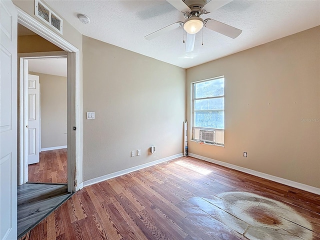 1741 Oak Spring Dr, Tarpon Springs, FL 34689 - empty room with wood finished floors, cooling unit, a ceiling fan, and a textured ceiling
