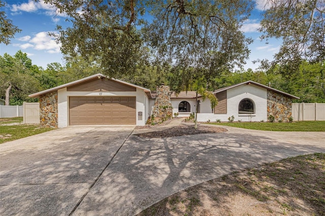 10430 Bobcat Dr, New Port Richey, FL 34654 - mid-century home featuring driveway, a garage, stone siding, and stucco siding