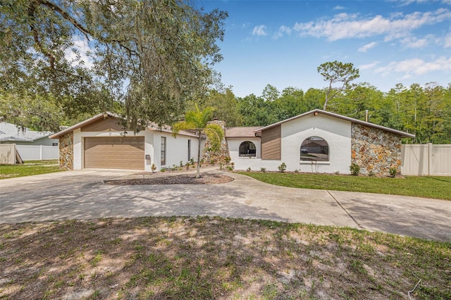 10430 Bobcat Dr, New Port Richey, FL 34654 - mid-century inspired home featuring concrete driveway, a garage, a chimney, stucco siding, and stone siding