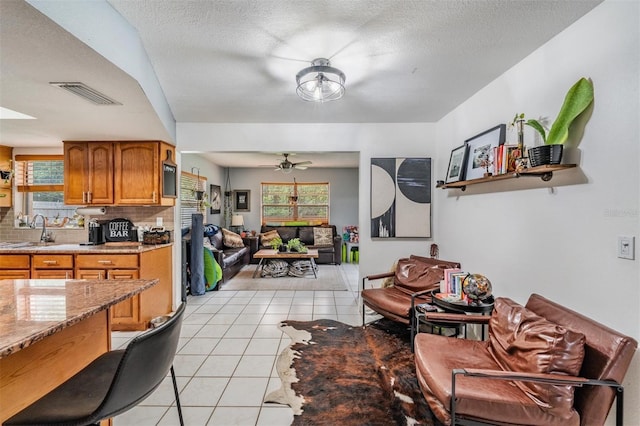 6101 Broken Arrow Dr, New Port Richey, FL 34653 - living area featuring healthy amount of natural light, light tile patterned flooring, a ceiling fan, and a textured ceiling