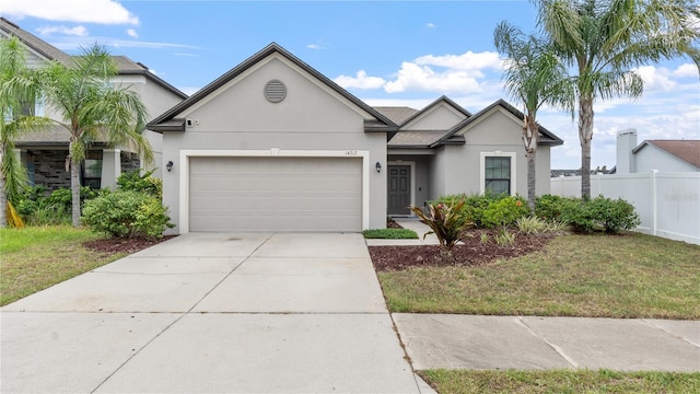 14317 Italia Dr, Wimauma, FL 33598 - view of front facade with stucco siding, a garage, and driveway