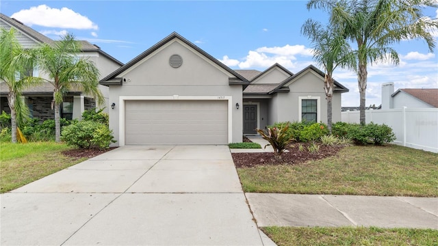 14317 Italia Dr, Wimauma, FL 33598 - view of front of house with stucco siding, an attached garage, and driveway
