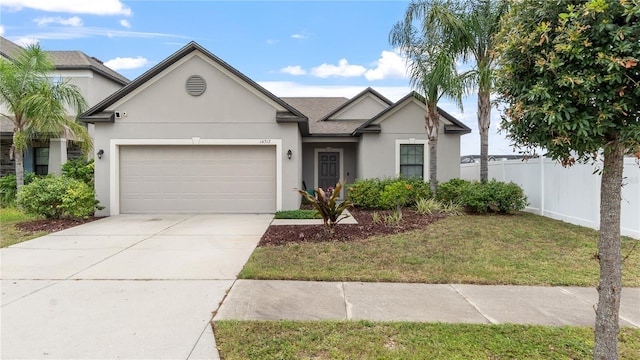 14317 Italia Dr, Wimauma, FL 33598 - view of front of house with stucco siding, a garage, and driveway