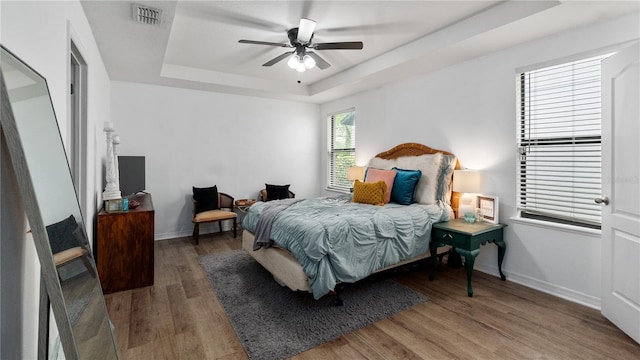 14317 Italia Dr, Wimauma, FL 33598 - bedroom with a tray ceiling, wood finished floors, and a ceiling fan
