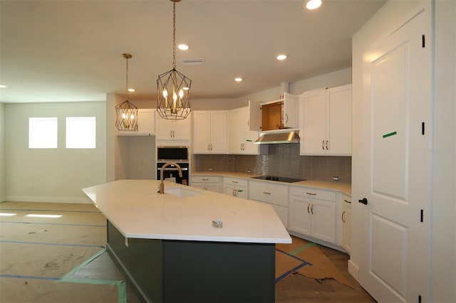 28792 Rambutan Dr, Wesley Chapel, FL 33543 - kitchen featuring black appliances, backsplash, recessed lighting, white cabinetry, and a kitchen island with sink