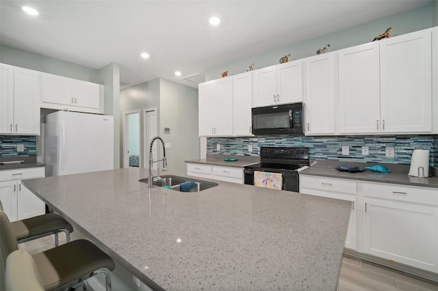 11829 Brighton Knoll Loop, Riverview, FL 33579 - kitchen with black appliances, a center island with sink, backsplash, a kitchen bar, and recessed lighting