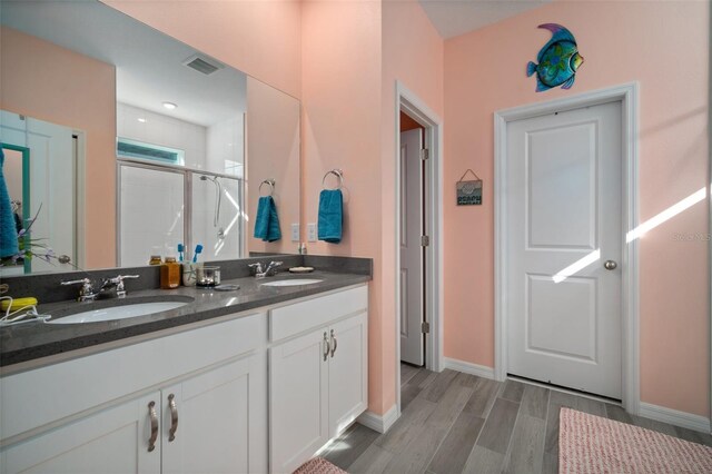 11829 Brighton Knoll Loop, Riverview, FL 33579 - full bath with double vanity, a tile shower, and wood finished floors