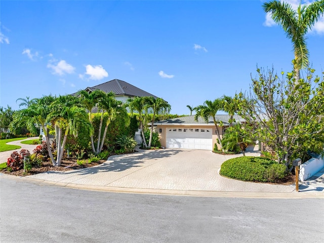 11085 9th St E, Treasure Island, FL 33706 - view of front of house with an attached garage, concrete driveway, and stucco siding