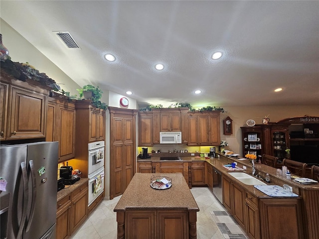 6900 Molakai Cir, Boynton Beach, FL 33437 - kitchen with stainless steel appliances, a peninsula, a kitchen island, recessed lighting, and brown cabinetry