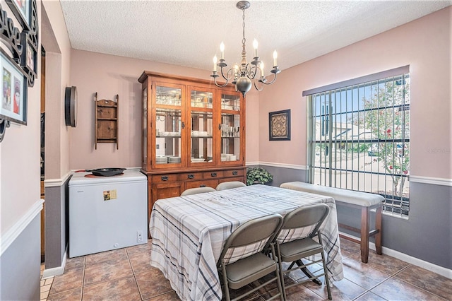 750 Caliente Dr, Brandon, FL 33511 - dining room featuring a chandelier, a textured ceiling, and light tile patterned floors
