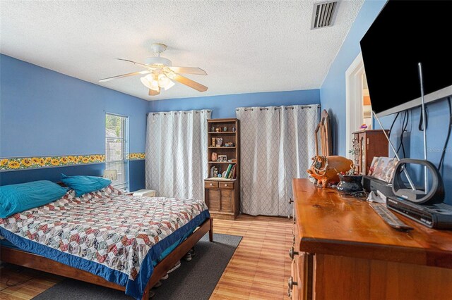 750 Caliente Dr, Brandon, FL 33511 - bedroom with light wood finished floors, a textured ceiling, and a ceiling fan