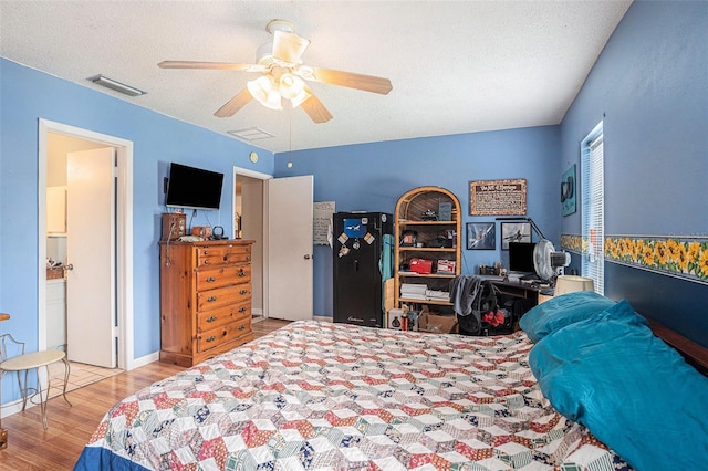 750 Caliente Dr, Brandon, FL 33511 - bedroom with wood finished floors, a textured ceiling, a ceiling fan, and ensuite bathroom
