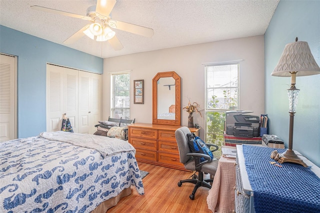 750 Caliente Dr, Brandon, FL 33511 - bedroom with light wood finished floors, a textured ceiling, a ceiling fan, and two closets