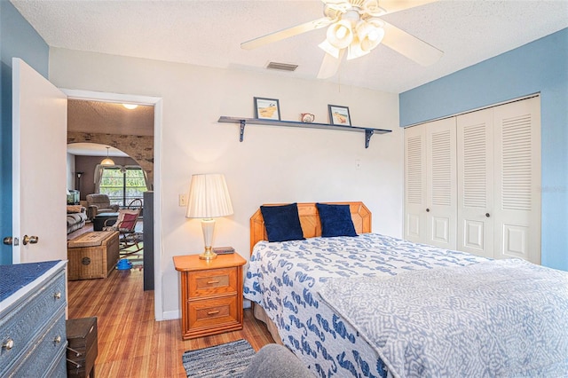 750 Caliente Dr, Brandon, FL 33511 - bedroom with light wood-type flooring, a closet, ceiling fan, and a textured ceiling
