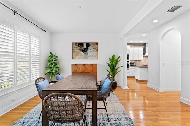305 Sea Island Way, Tampa, FL 33602 - dining area featuring light wood finished floors, arched walkways, recessed lighting, and decorative columns