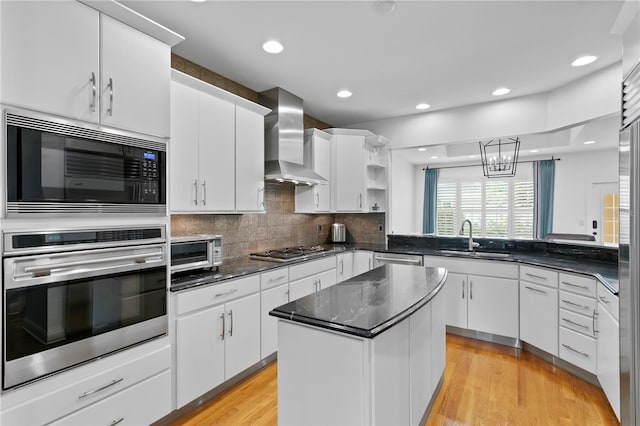 305 Sea Island Way, Tampa, FL 33602 - kitchen featuring appliances with stainless steel finishes, wall chimney exhaust hood, open shelves, a kitchen island, and white cabinetry