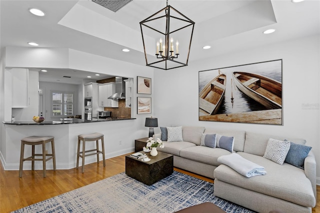305 Sea Island Way, Tampa, FL 33602 - living room with recessed lighting, light wood-style floors, a chandelier, and a raised ceiling