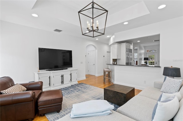 305 Sea Island Way, Tampa, FL 33602 - living area with recessed lighting, a raised ceiling, arched walkways, light wood-style floors, and a chandelier