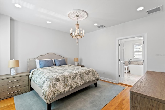305 Sea Island Way, Tampa, FL 33602 - bedroom featuring light wood-type flooring, a chandelier, recessed lighting, and ensuite bath