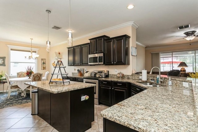 2639 Yukon Cliff Dr, Ruskin, FL 33570 - kitchen with appliances with stainless steel finishes, light tile patterned floors, light stone counters, a kitchen island, and crown molding