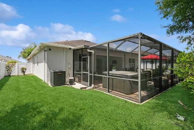 2639 Yukon Cliff Dr, Ruskin, FL 33570 - back of house with a hot tub, a fenced backyard, stucco siding, and glass enclosure