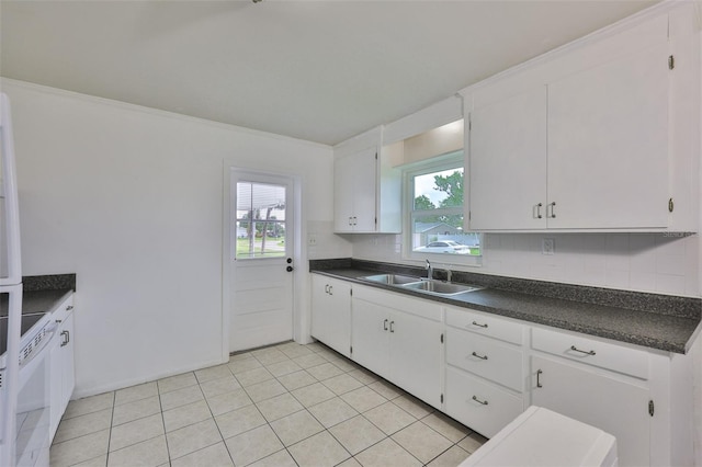 106 W N Branch Rd, Ruskin, FL 33570 - kitchen with dark countertops, backsplash, light tile patterned flooring, and white cabinetry