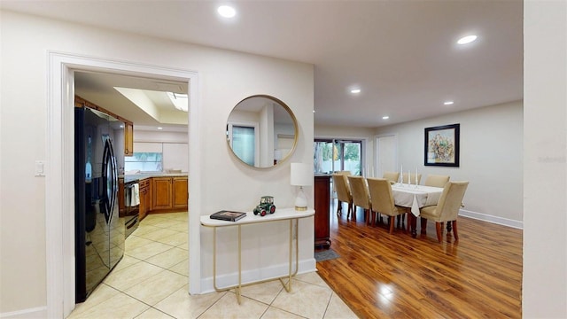 14424 Neptune Rd, Seminole, FL 33776 - kitchen with freestanding refrigerator, recessed lighting, brown cabinetry, light countertops, and light wood-style floors