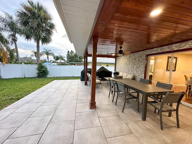 14424 Neptune Rd, Seminole, FL 33776 - fenced backyard with outdoor dining area, a patio, ceiling fan, and a grill