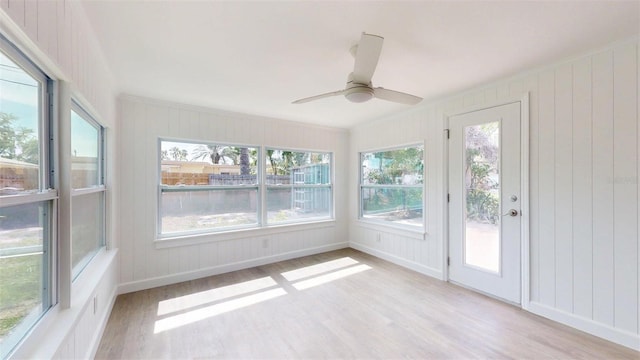 1431 Island Dr S, South Pasadena, FL 33707 - unfurnished sunroom with wood finished floors, healthy amount of natural light, and a decorative wall