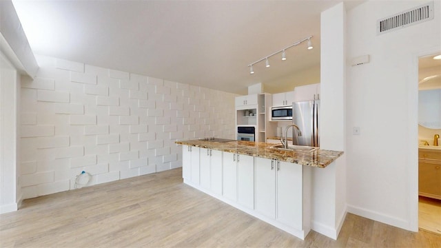 1431 Island Dr S, South Pasadena, FL 33707 - kitchen featuring stainless steel appliances, track lighting, white cabinetry, light stone counters, and light wood-style flooring