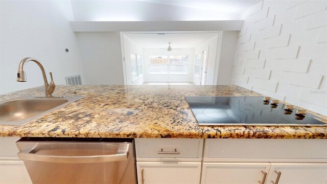 1431 Island Dr S, South Pasadena, FL 33707 - kitchen featuring dishwasher, black electric cooktop, white cabinets, light stone countertops, and a ceiling fan