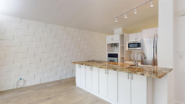 1431 Island Dr S, South Pasadena, FL 33707 - kitchen featuring appliances with stainless steel finishes, light stone countertops, a peninsula, white cabinets, and rail lighting