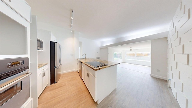 1431 Island Dr S, South Pasadena, FL 33707 - kitchen with appliances with stainless steel finishes, white cabinetry, and light wood-style floors