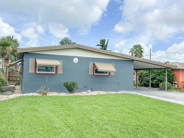 1431 Island Dr S, South Pasadena, FL 33707 - view of side of home with a yard, a carport, and concrete driveway