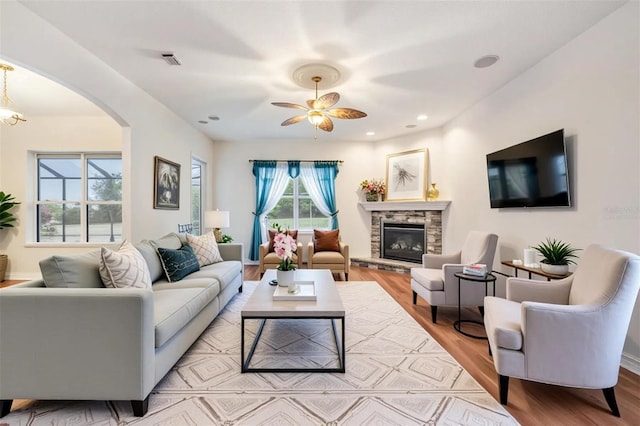 117 Camelot Ridge Dr, Brandon, FL 33511 - living area featuring wood finished floors, arched walkways, a stone fireplace, ceiling fan, and recessed lighting