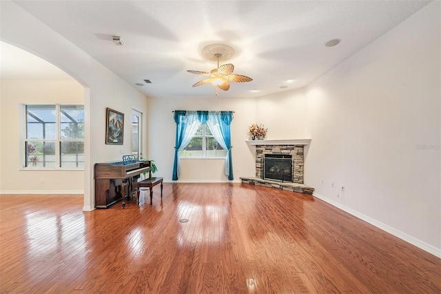117 Camelot Ridge Dr, Brandon, FL 33511 - living area featuring a ceiling fan, arched walkways, wood finished floors, and a fireplace