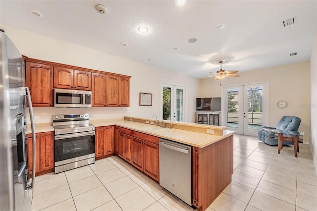 117 Camelot Ridge Dr, Brandon, FL 33511 - kitchen featuring appliances with stainless steel finishes, french doors, open floor plan, a peninsula, and plenty of natural light