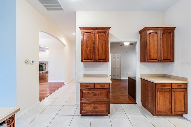 117 Camelot Ridge Dr, Brandon, FL 33511 - kitchen featuring arched walkways, light countertops, a ceiling fan, and light tile patterned flooring