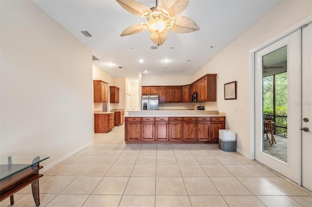 117 Camelot Ridge Dr, Brandon, FL 33511 - kitchen featuring appliances with stainless steel finishes, light countertops, brown cabinetry, a peninsula, and light tile patterned floors