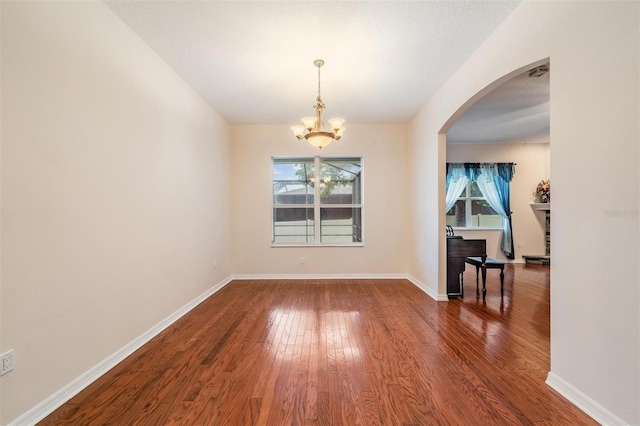 117 Camelot Ridge Dr, Brandon, FL 33511 - unfurnished room with wood finished floors, a chandelier, arched walkways, and lofted ceiling