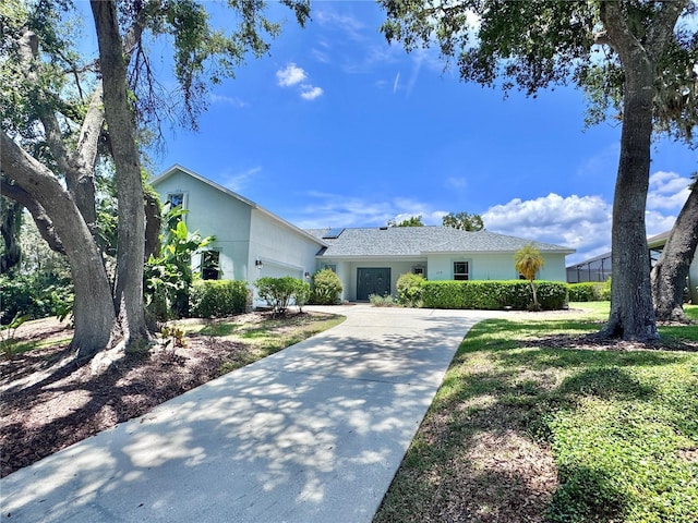 117 Camelot Ridge Dr, Brandon, FL 33511 - view of front of property with stucco siding, an attached garage, driveway, and roof mounted solar panels