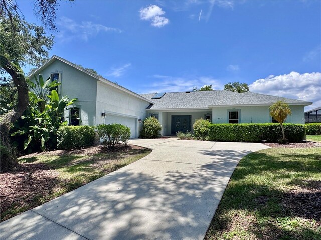 117 Camelot Ridge Dr, Brandon, FL 33511 - view of front facade with a garage, stucco siding, solar panels, and driveway