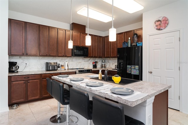 11444 Alachua Creek Ln, Riverview, FL 33579 - kitchen with black appliances, light countertops, tasteful backsplash, and a breakfast bar area