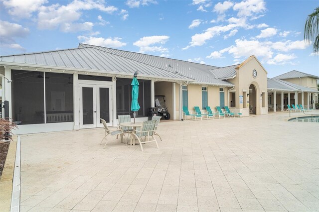 11444 Alachua Creek Ln, Riverview, FL 33579 - back of house with a sunroom, a patio area, stucco siding, french doors, and a metal roof