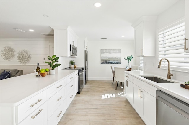 1908 Sutherland Dr W, Palm Harbor, FL 34683 - kitchen with appliances with stainless steel finishes, light countertops, white cabinetry, recessed lighting, and light wood-style floors